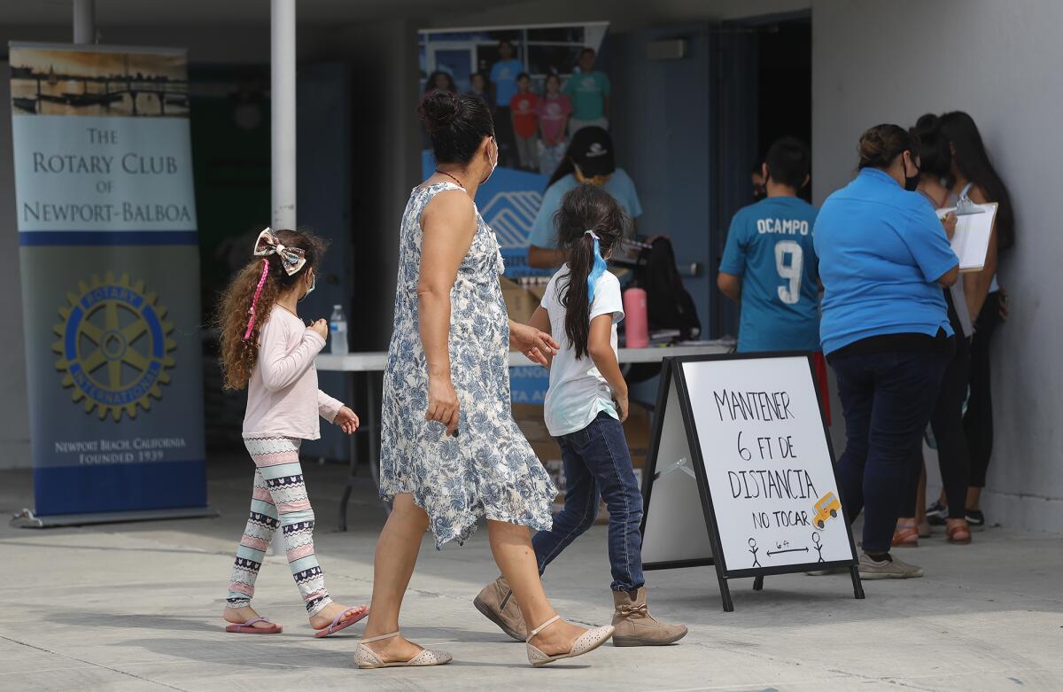 A family arrives for new school supplies on Friday at Rea Elementary School.