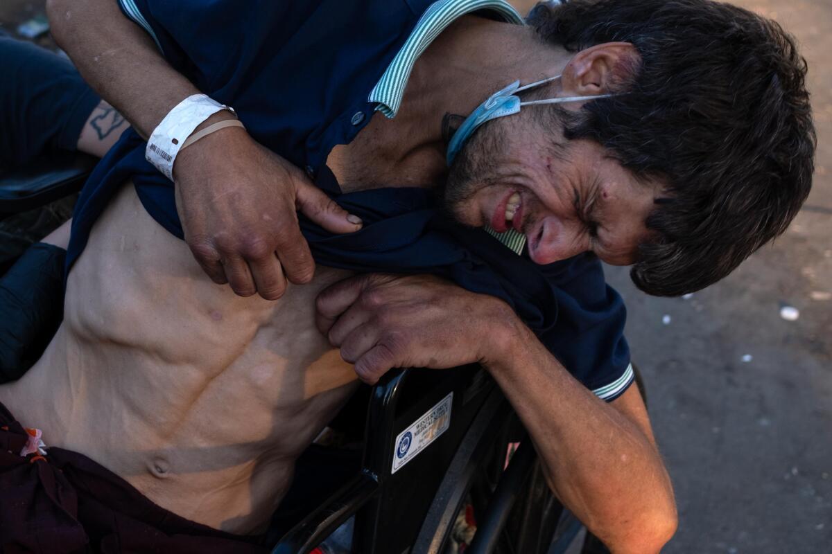 Aaron Conner, 20, sits in his wheelchair grimacing in pain on Nov. 19, 2023. He says he is recovering from hip surgery.