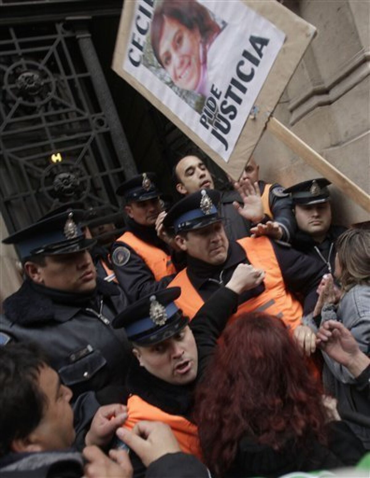 Demonstrators scuffle with police officers as they try to enter a courtroom in Buenos Aires, Wednesday, Aug. 19, 2009. Concert promoters, a police supervisor, city inspectors and a band manager were convicted and given prison terms in the 2004 Cromagnon nightclub fire that killed around 190 people. (AP Photo/Natacha Pisarenko)