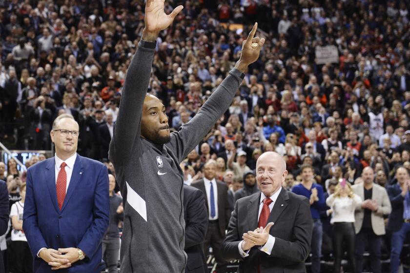 Former Toronto Raptors and now Los Angeles Clippers forward Kawhi Leonard salutes the crowd as he receives his 2019 NBA championship ring prior to an NBA basketball game, Wednesday, Dec. 11, 2019, in Toronto. (Nathan Denette/The Canadian Press via AP)