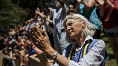 Tani Taylor claps for police officers during an interfaith prayer event for the victims of the mass shooting that killed five officers in Dallas.