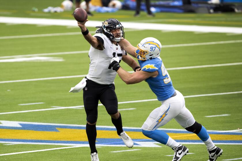INGLEWOOD, CA - OCTOBER 25: Jaguars quarterback Gardner Minshew II is forced to thrown the ball as Chargers defensive end Joey Bosa starts to bring him down in the first half amid an empty SoFi Stadium on Sunday, Oct. 25, 2020 in Inglewood, CA. (Allen J. Schaben / Los Angeles Times)