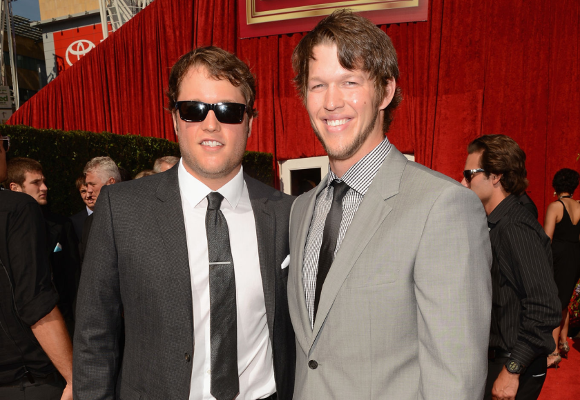 Matthew Stafford and Clayton Kershaw smile as they pose for a photo together on a red carpet.