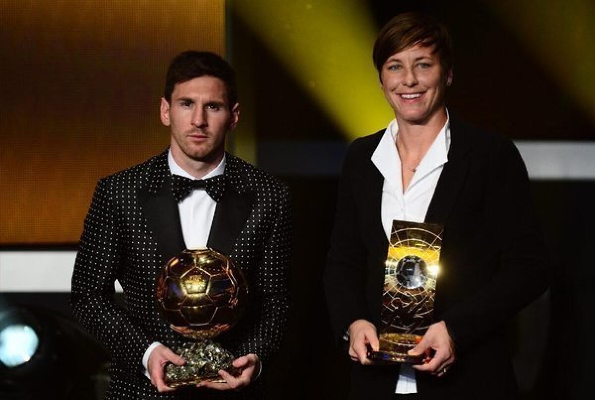 Lionel Messi and Abby Wambach accept their awards.