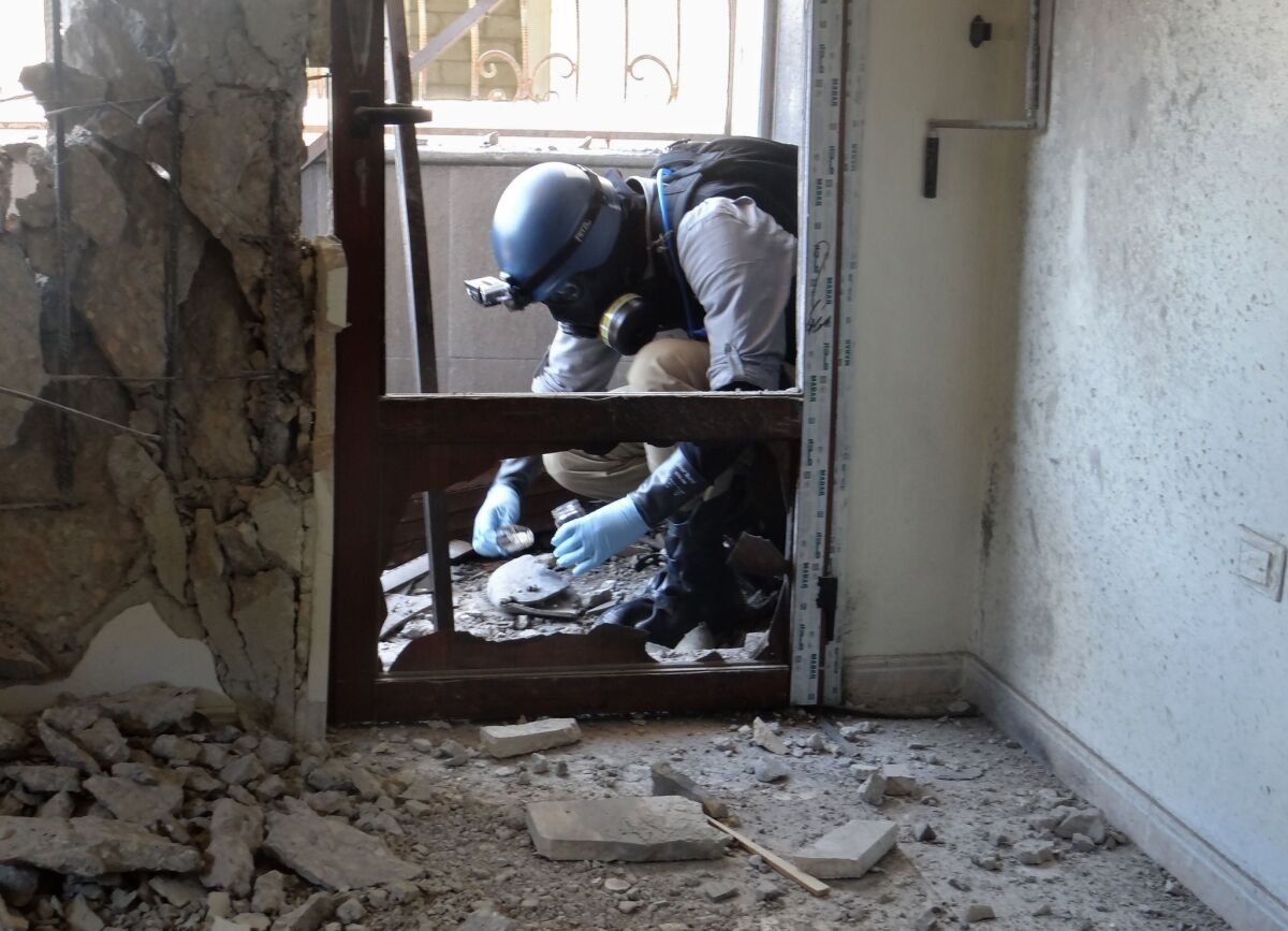 A U.N. arms expert collects samples during an investigation into a suspected chemical weapons strike near Damascus in 2013.