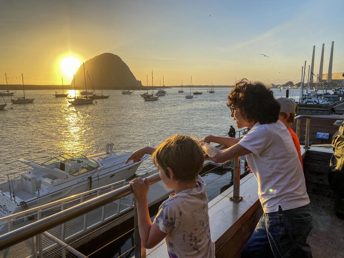Visitors take in the sunset over Morro Bay.
