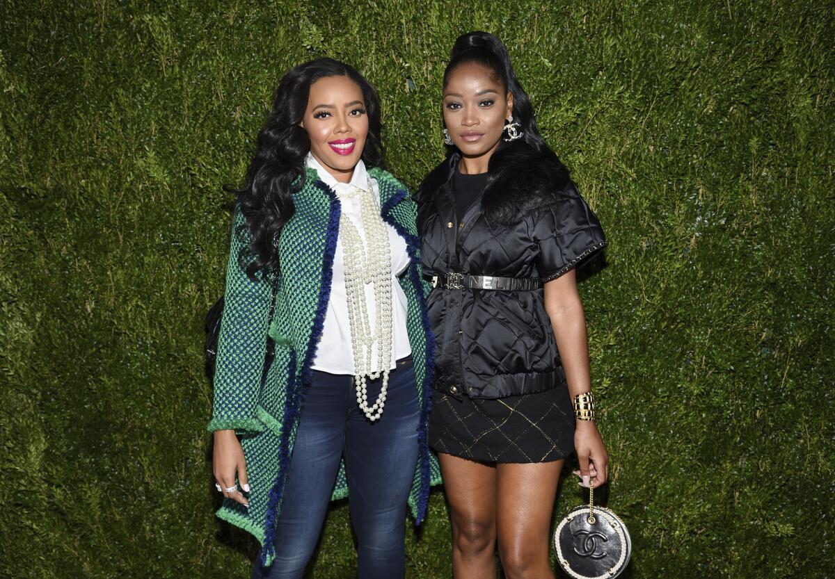 Angela Simmons, left, and Keke Palmer in front of a green backdrop. 