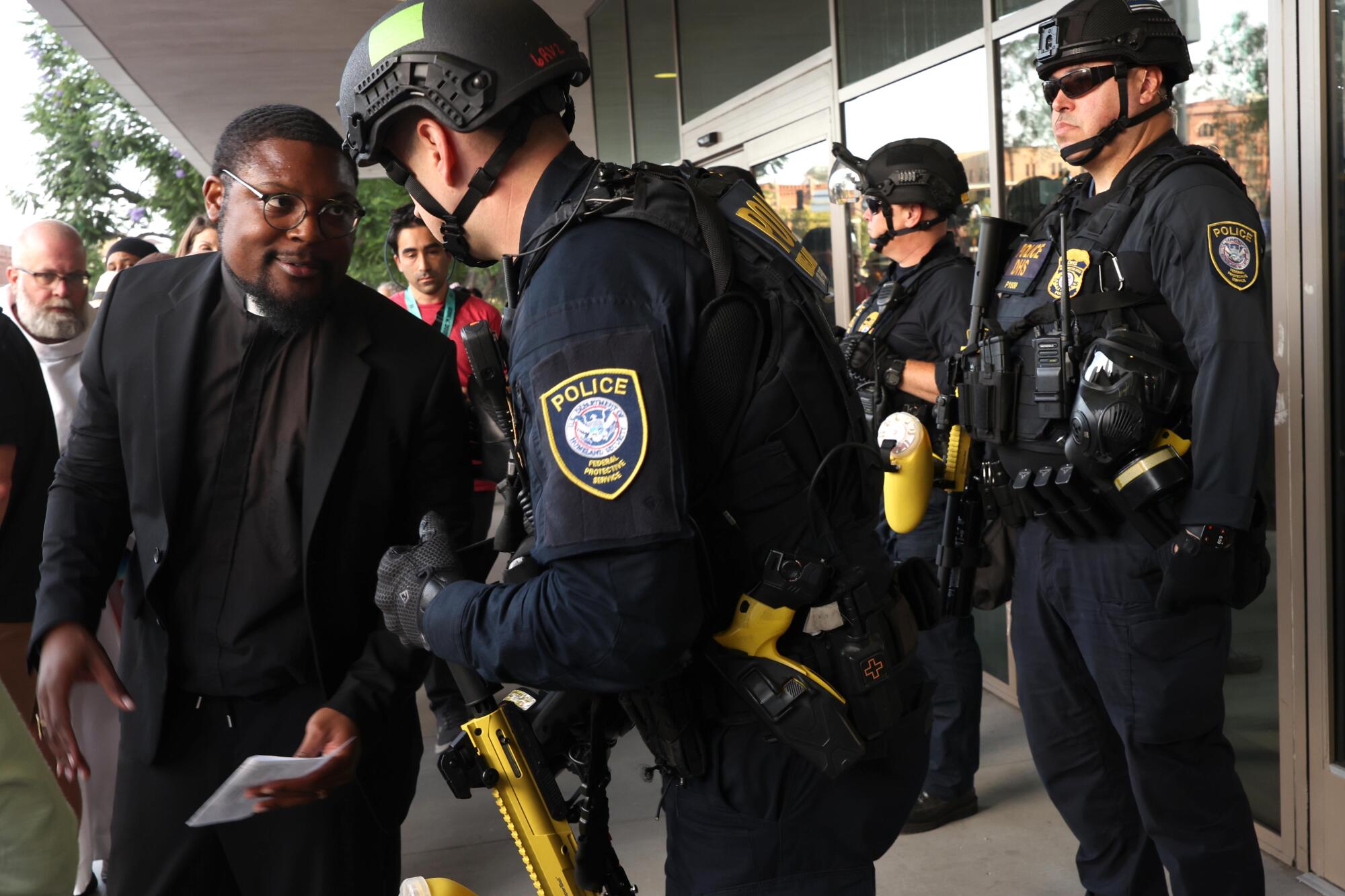 Pastor Eddie Anderson assures a police officer that the crowd will be peaceful in front of the Federal Building.