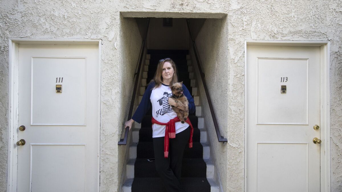 Renter Holly Morris, with her dog Mr. Wilson, is facing a 40% rent increase after the building was removed from rent control. The owners say the increases are allowing them to make needed investments.