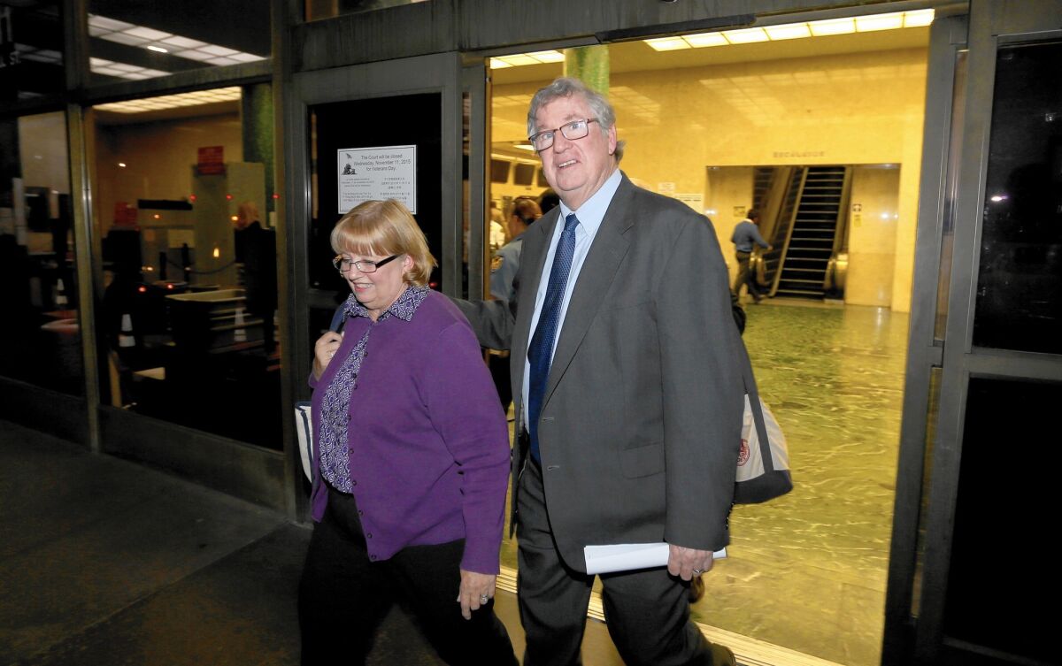 Former Times sports columnist T.J. Simers and his wife, Ginny, leave an L.A. courthouse Wednesday after he won a discrimation case against the newspaper.