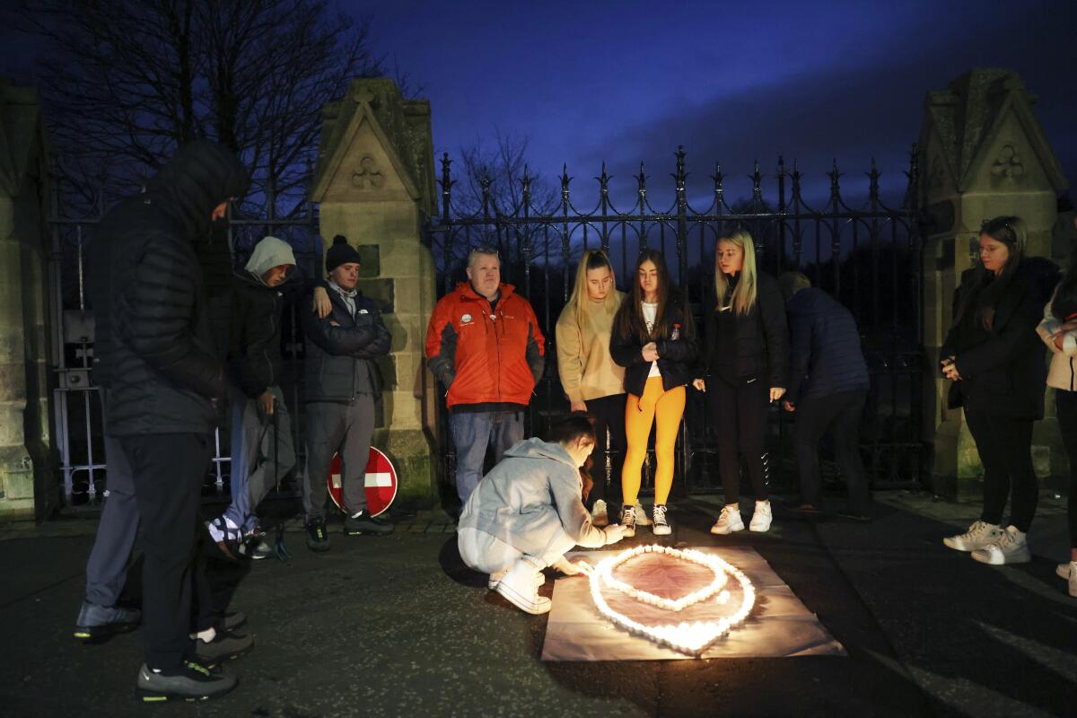 People light candles at Belfast City cemetery for Holocaust Remembrance Day.