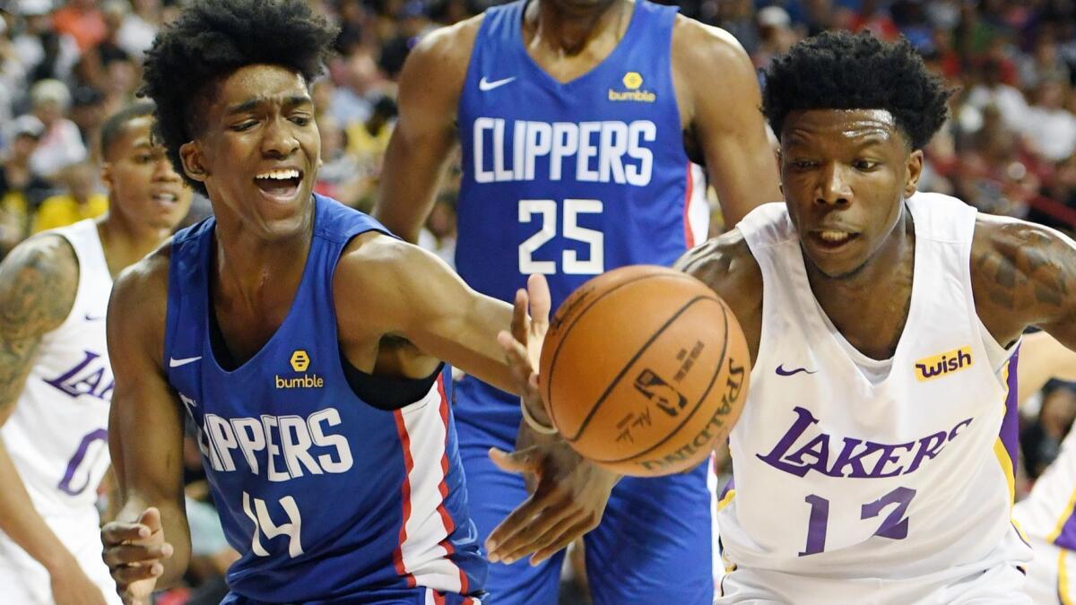 Clippers guard Terance Mann battles Lakers guard Devontae Cacok for a loose ball during a summer league game Sunday in Las Vegas.