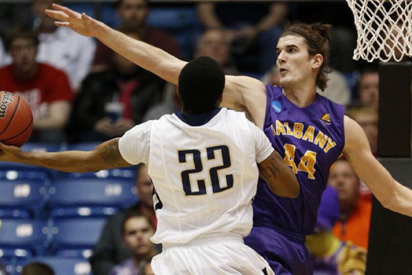 Mount St. Mary's Rashad Whack, left, puts up a shot in front of Albany's John Puk during the first half of Albany's 71-64 win on Tuesday.