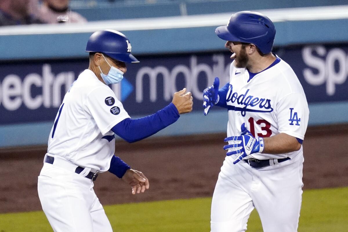 Dodgers first baseman Max Muncy celebrates with third base coach Dino Ebel after hitting a three-run home run.