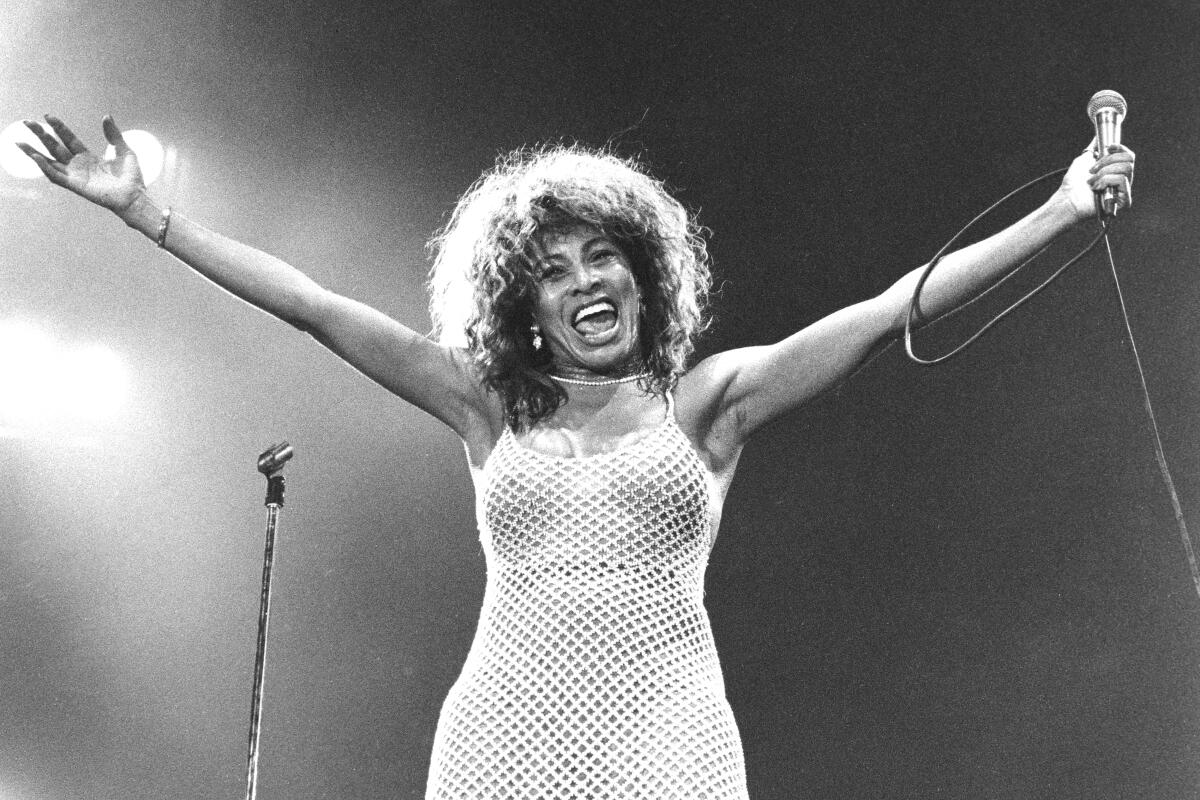 Tina Turner onstage with her arms outstretched