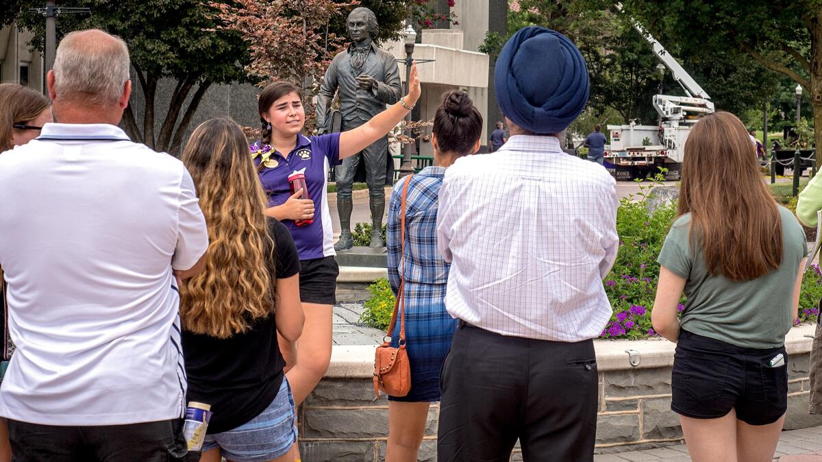 A James Madison University tour guide leads a group of prospective high school students around campus on Aug. 1, 2016, in Harrisonburg, Va.