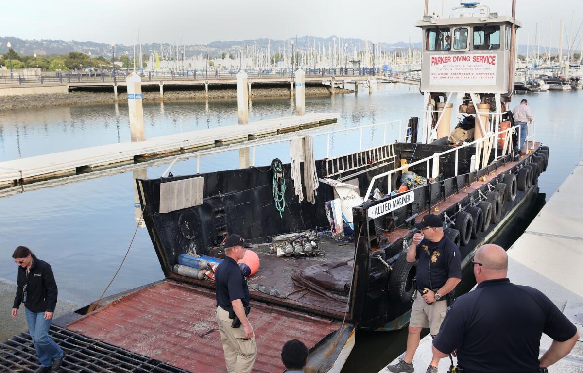 Contra Costa Sheriff's deputies and NTSB officials arrive at the dock with the wreckage of a Cessna 210 and body of the pilot at the Marina Bay Yacht Harbor in Richmond.