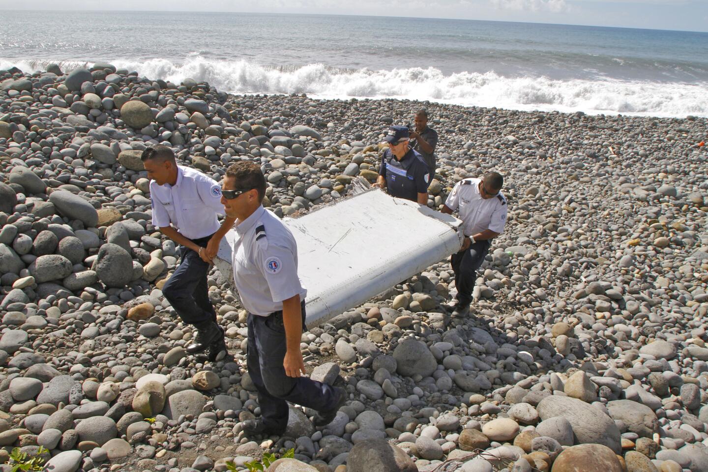 French police officers carry a piece of debris from a plane in Saint-Andre, Reunion Island. Air safety investigators, one of them a Boeing investigator, have identified the component as a "flaperon" from the trailing edge of a Boeing 777 wing, a U.S. official said. Malaysian Airlines Flight 370, which disappeared March 8, 2014, with 239 people on board, is the only 777 known to be missing.
