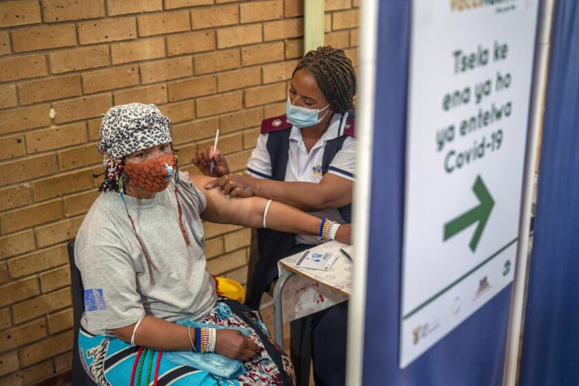 An Orange Farm, South Africa, resident receives her jab against COVID-19 Friday Dec. 3, 2021 at the Orange Farm multipurpose center. South Africa has accelerated its vaccination campaign a week after the discovery of the omicron variant of the coronavirus. (AP Photo/Jerome Delay)