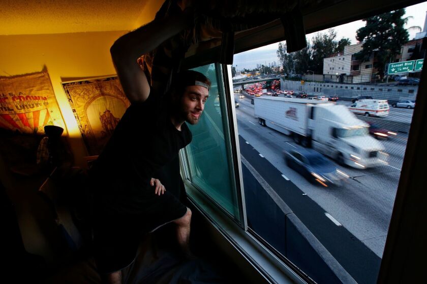 HOLLYWOOD, CA-FEBRUARY 4, 2017: More than 1.2 million people already live in high-pollution zones within 500 feet of a Southern California freeway, with more moving in every day. Mason Miller looks out of his bedroom window that is located right next to the northbound lanes of the 101 freeway in Hollywood. Miller, who lives in an apartment on Tamarind Ave. with 3 others, said that he has to always keep the window shut and put a blanket over it to keep the noise out. (Mel Melcon/Los Angeles Times)