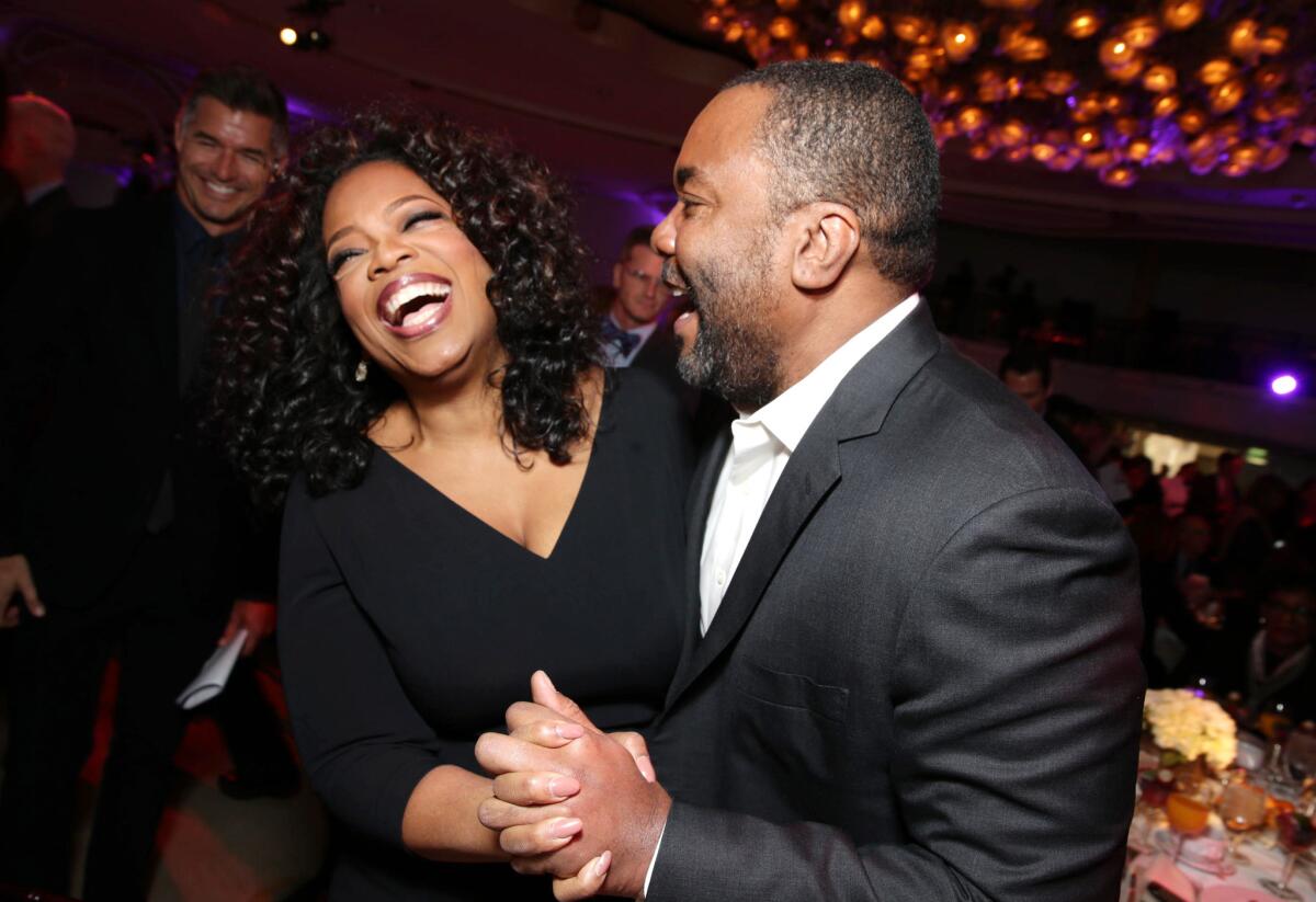 Oprah Winfrey and Lee Daniels, who directed her in "The Butler," share a laugh at the Hollywood Reporter's "Power 100" Women in Entertainment Breakfast on Wednesday in Beverly Hills.