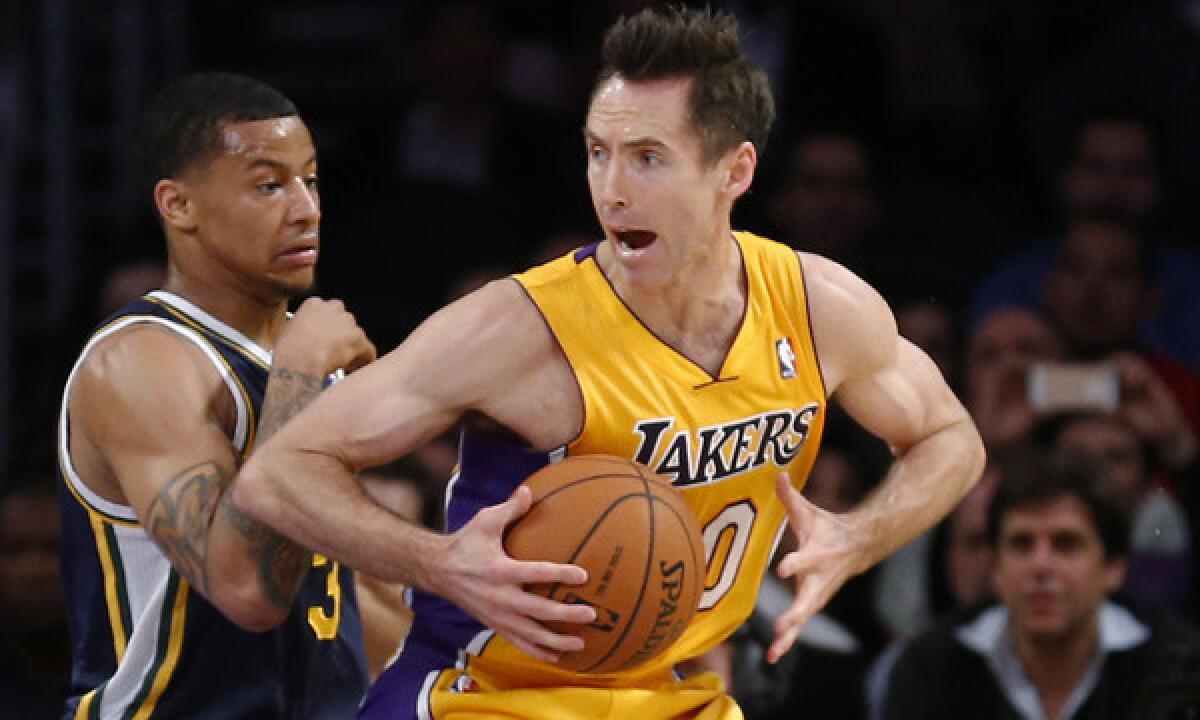 Lakers guard Steve Nash, right, tries to move around Utah's Trey Burke during a game on Feb. 11. Nash says he wants to play for the Lakers next season.