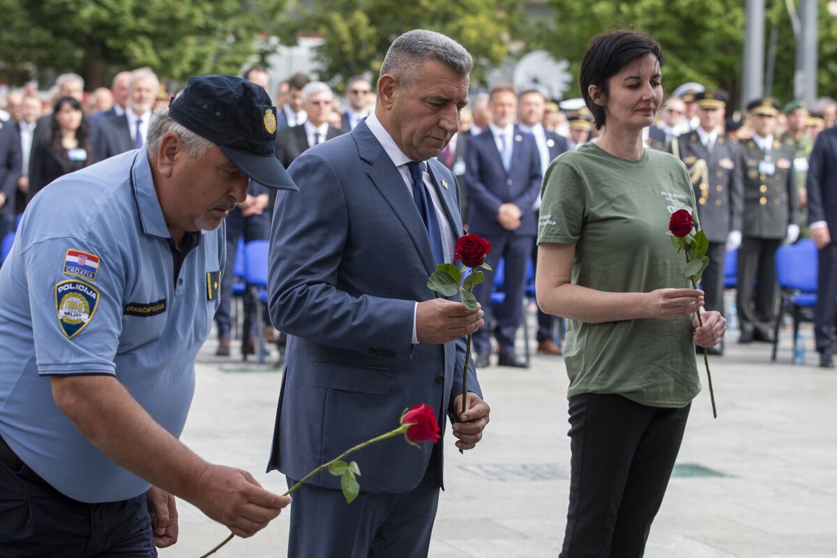 Croatian Gen. Ret. Ante Gotovina places flowers during a ceremony in Knin, Croatia, Wednesday, Aug. 5, 2020. Croatia marked the 25th anniversary of a victorious wartime military offensive, with an ethnic Serb politician attending the ceremony for the first time in what is seen as an important step toward reconciliation. (AP Photo/Darko Bandic)