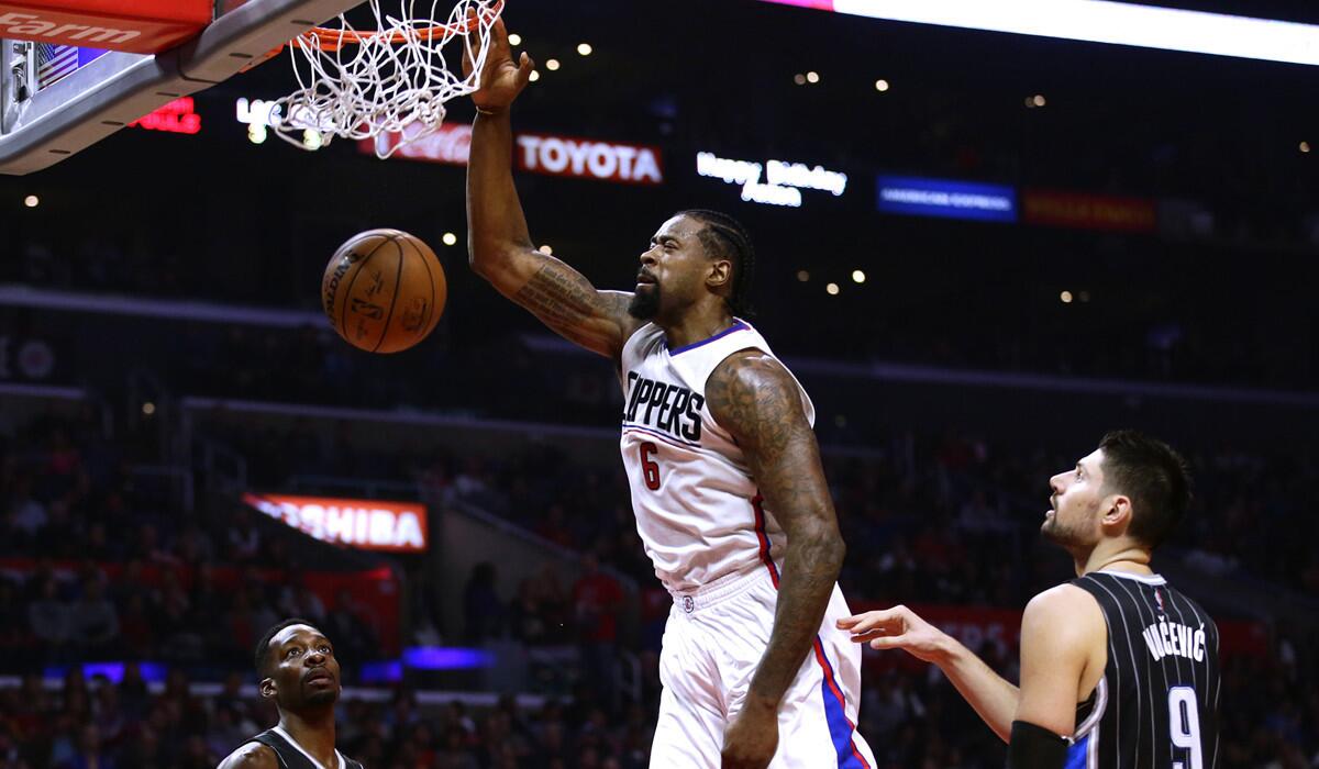 Clippers center DeAndre Jordan (6) makes a slam dunk over Magic players Jeff Green, left, and Nikola Vucevic during first half action at Staples Center.