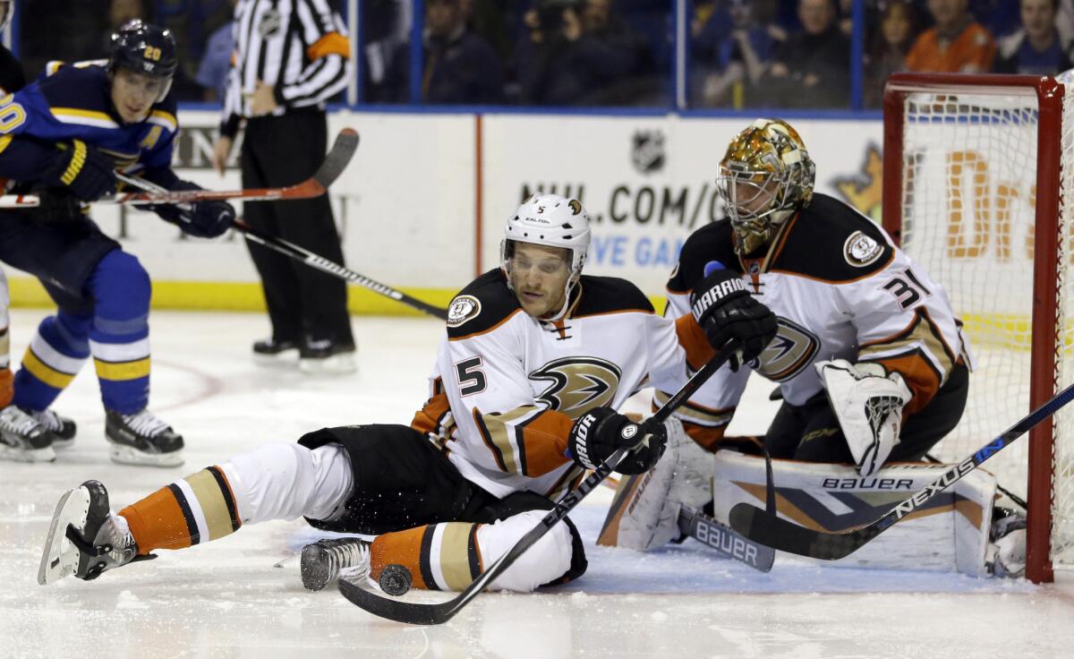 Ducks' Korbinian Holzer (5) tries to clear a puck as goalie Frederik Andersen (31) watches during a game on Oct. 29.