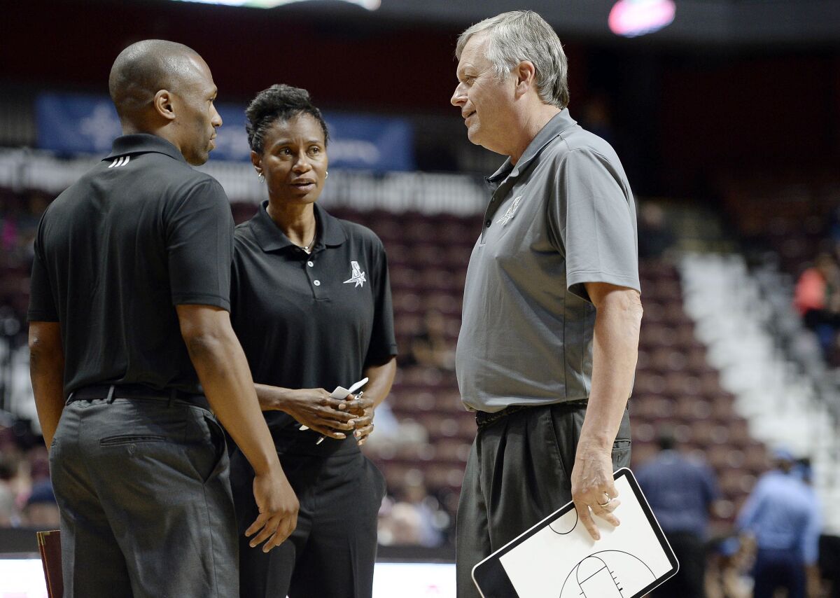 FILE - In this May 4, 2016 file photo, San Antonio Stars coach Dan Hughes talks with assistant coaches James Wade, left, and Vickie Johnson, center, during the first half of the team's WNBA basketball exhibition game against the Atlanta Dream in Uncasville, Conn. Vickie Johnson has agreed in principle to be the next coach of the Dallas Wings, said a person familiar with the situation. The person spoke to The Associated Press Thursday, Dec. 3, 2020 on condition of anonymity to the AP because the no announcement of Johnson’s hiring has been made. (AP Photo/Jessica Hill, File)