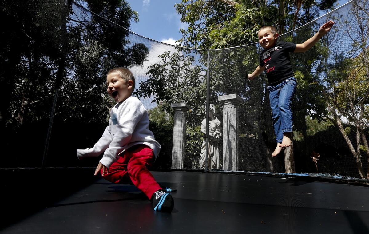 Lucian Olivera, left, and his brother Nikolas play on a trampoline at their home in Moorpark.