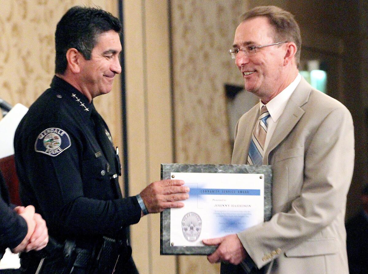 Johnny Harrison, right, gets one of three "Community Service" awards during the annual police awards luncheon on Thursday, May 15, 2014.