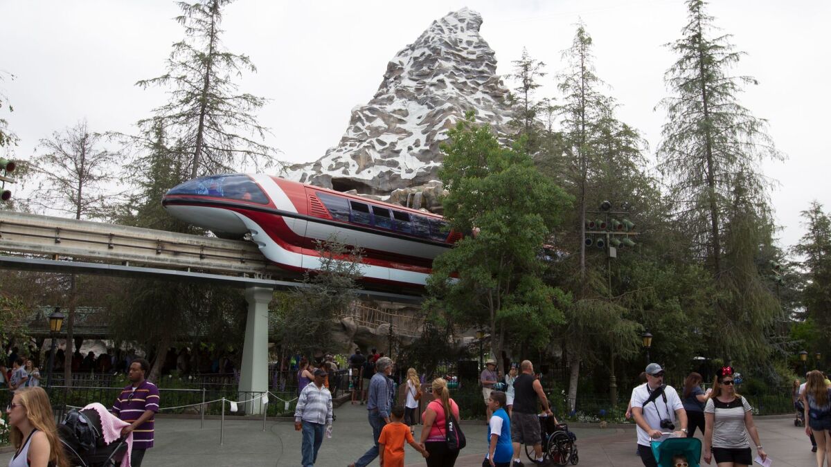 The Disneyland Monorail passes by the Matterhorn Bobsleds ride in the background.