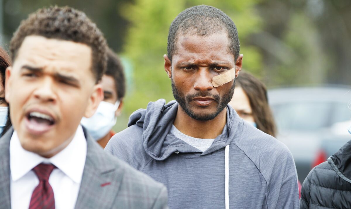 Jesse Evans, 34, appears at a May 14 news conference in La Jolla held by the Rev. Shane Harris (left).