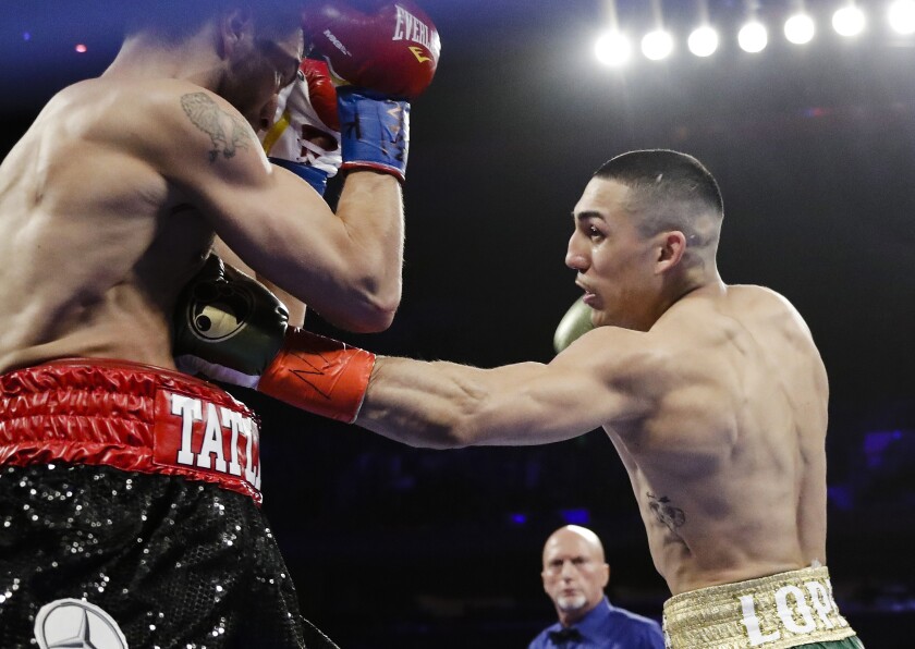 FILE - In this April 20, 2019, file photo, Teofimo Lopez, right, punches Finland's Edis Tatli during the first round of a boxing bout in New York. Lopez is symptomatic after testing positive for COVID-19, and his bout with mandatory challenger George Kambosos has been postponed until Aug. 14. Lopez and Kambosos were scheduled to fight Saturday night at the Miami Marlins' home stadium. (AP Photo/Frank Franklin II, File)
