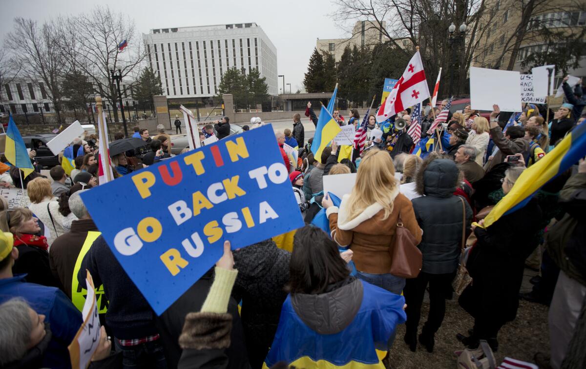 Demonstrators are seen at a protest rally in front of the Russian embassy in Washington. Igniting a tense standoff, Russian forces surrounded a Ukrainian army base Sunday just as Ukraine began mobilizing in response to the surprise Russian takeover of Crimea. Outrage over Russia's tactics mounted in world capitals, with U.S. Secretary of State John Kerry calling on President Vladimir Putin to pull back from "an incredible act of aggression."
