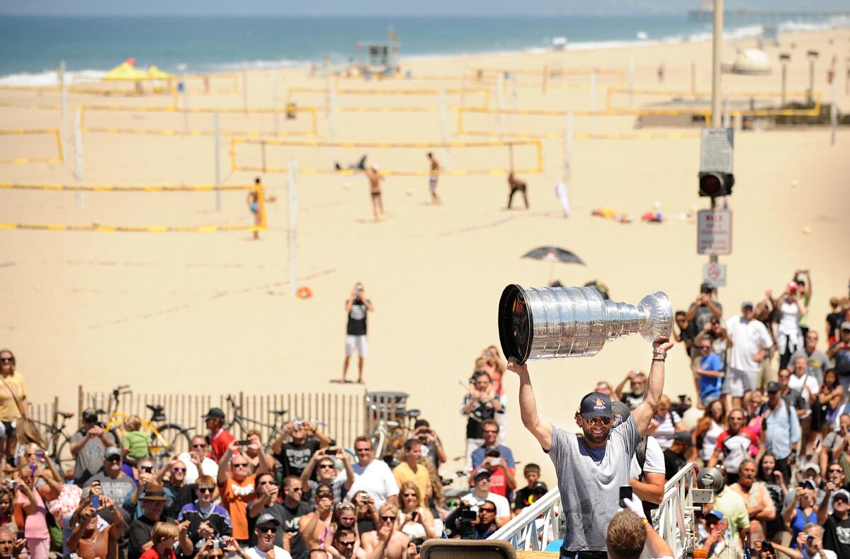 Then-Kings center Jarrett Stoll raises the Stanley Cup among a crowd of fans at Hermosa Beach.