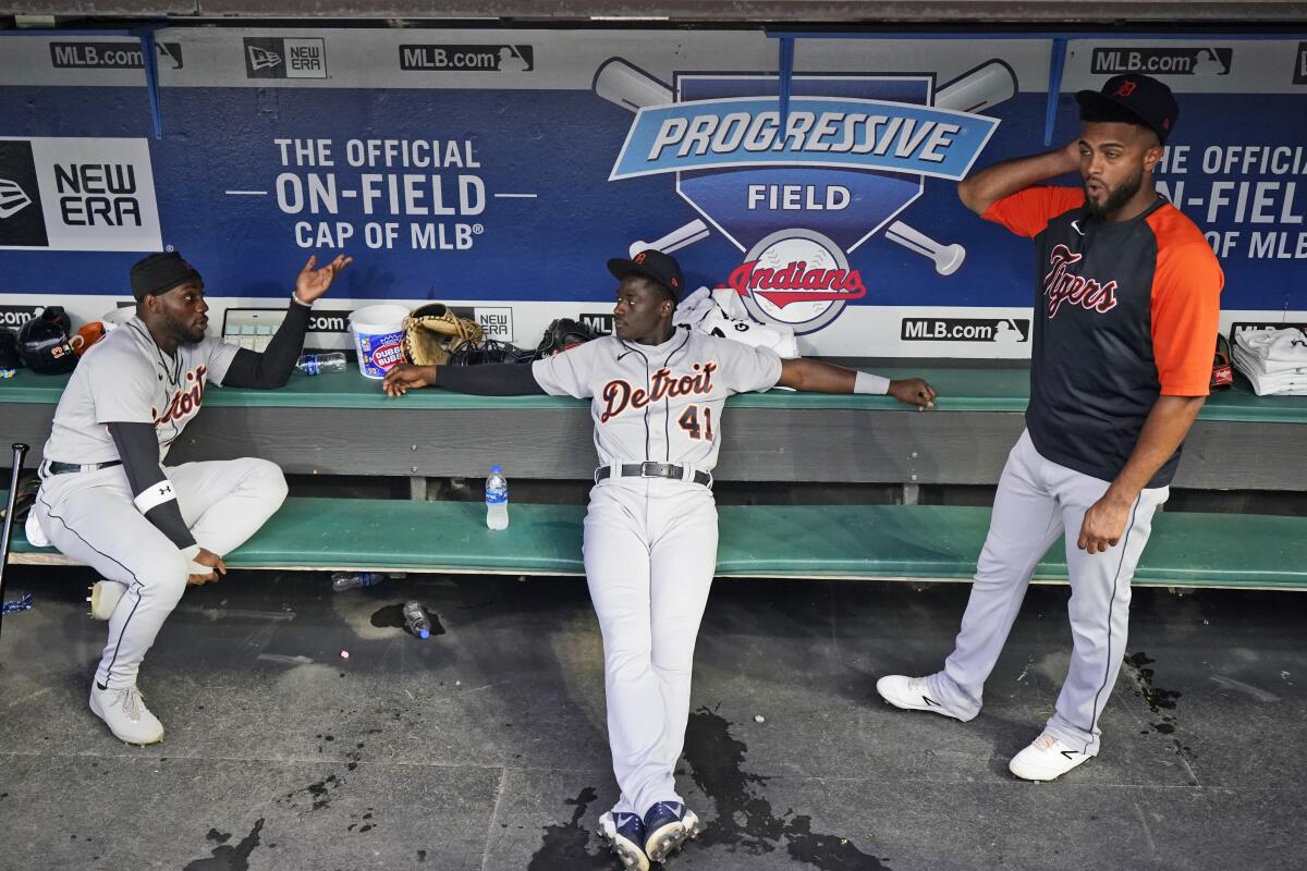 Detroit Tigers' Akil Baddoo, left to right, Derek Holland and Willi Castro talk during a rain delay before a baseball game against the Cleveland Indians, Tuesday, June 29, 2021, in Cleveland. (AP Photo/Tony Dejak)