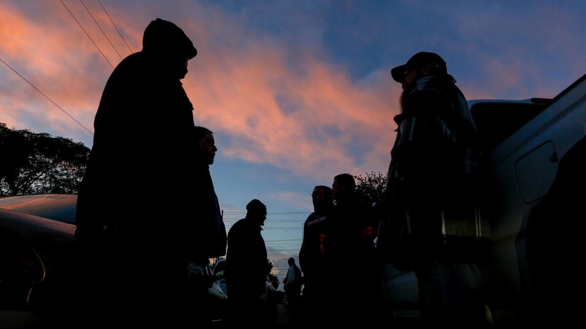 Part-timers gather near the dispatch hall early in the morning. (Mark Boster / Los Angeles Times)