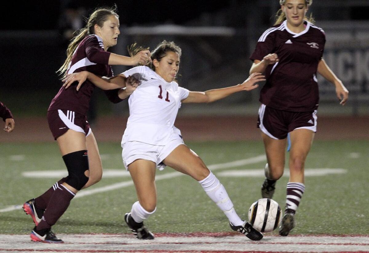 Estancia High's Alba Barrios, center, battles Laguna Beach's Katelyn Carballo, left, and Audrey Pillsbury, right, for the ball during the second half in an Orange Coast League game at Jim Scott Stadium on Thursday.