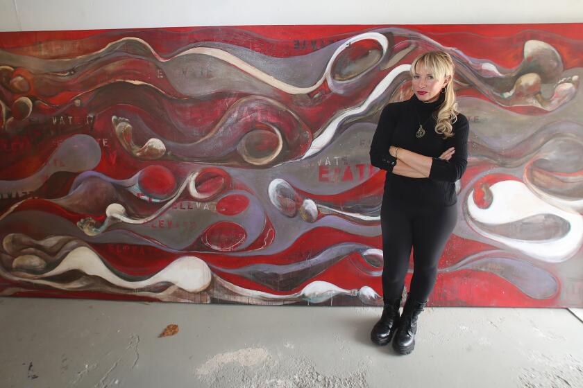 Local artist Christiana Lewis stands next to her painting, 'Elevate,' which was stolen from an underground parking garage after a show at the Laguna Gallery of Contemporary Art in 2014 in Laguna Beach. To her surprise, the painting was found and returned to her earlier this year.