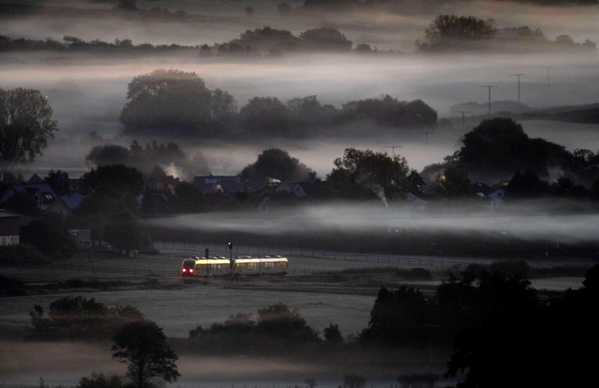 FILE - A regional train passes fog-covered fields in Wehrheim near Frankfurt, Germany, Oct. 7, 2022. Germany's federal and state transport officials said Thursday they want to introduce a public transit pass that costs 49 euros, 47 dollars, a month and be valid nationwide. (AP Photo/Michael Probst, File)