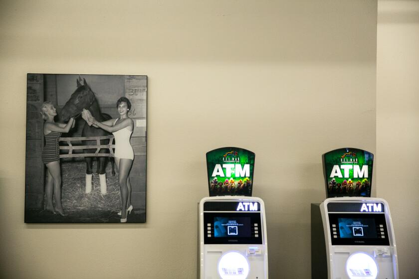 A historical photo hangs next to two ATMs as fans arrive at the Del Mar Racetrack on the day that two horses died in a training accident on July 18, 2019 in Del Mar, California.