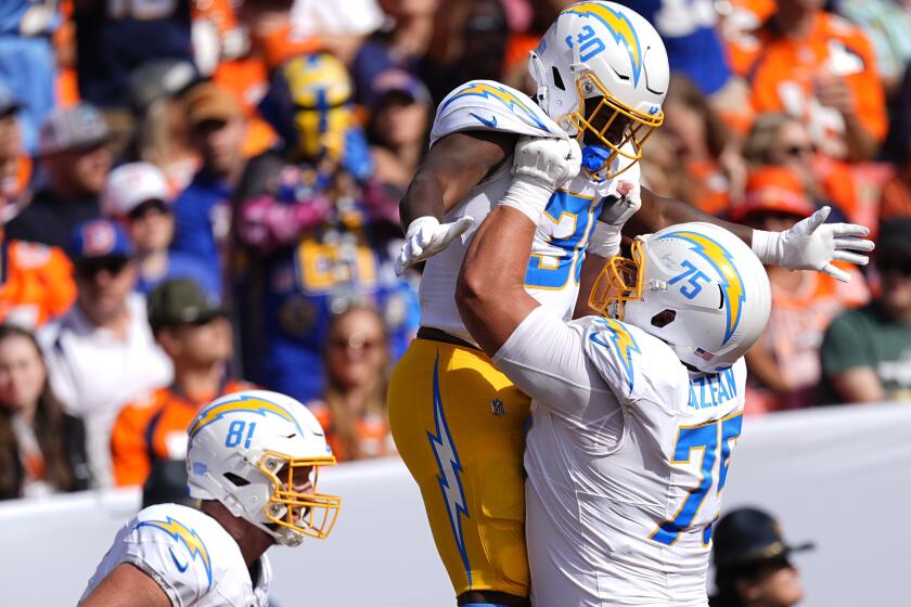 Los Angeles Chargers running back Kimani Vidal (30) celebrates his touchdown with center Bradley Bozeman.