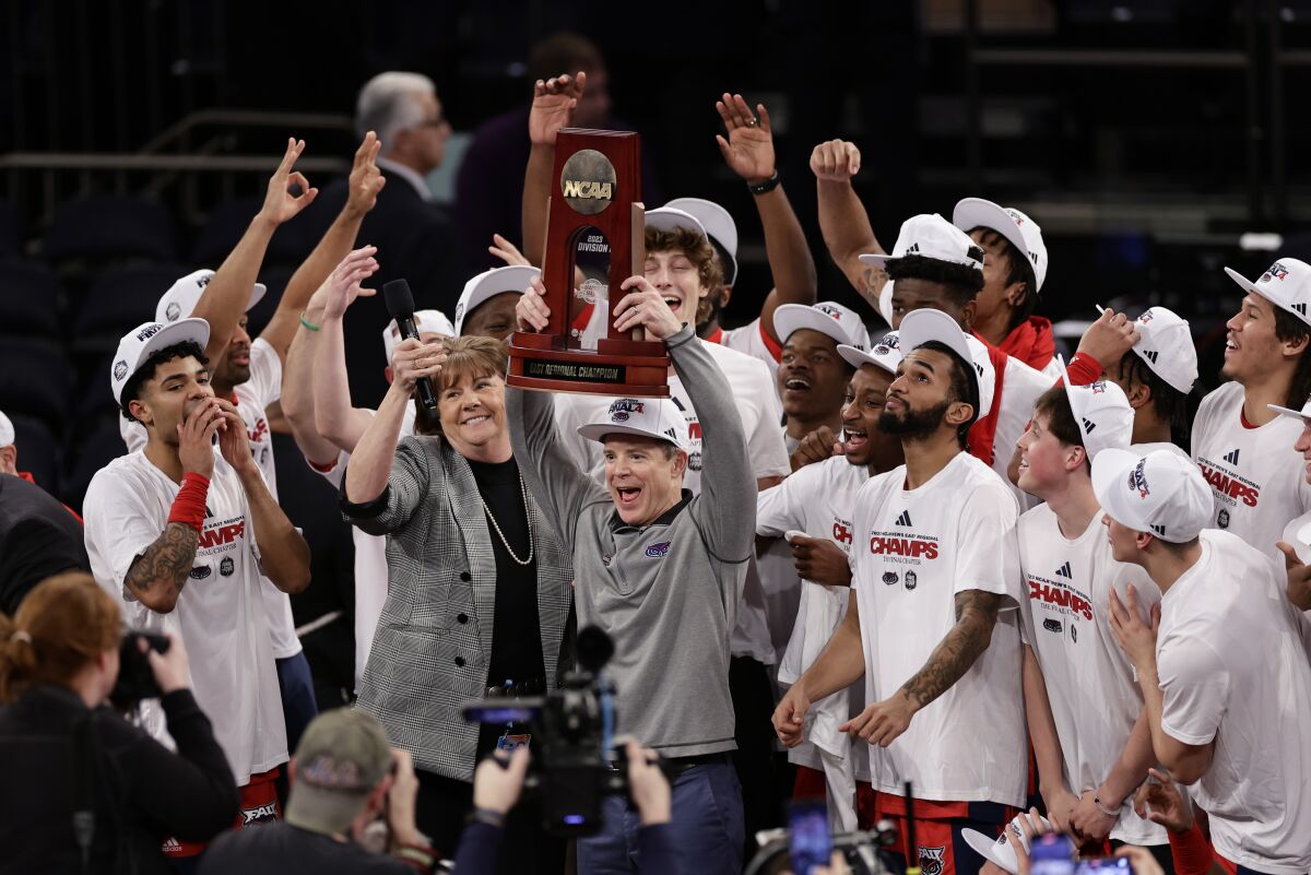 Florida Atlantic head coach Dusty May holds up the championship trophy after Florida Atlantic defeated Kansas State 79-86 in an Elite 8 college basketball game in the NCAA Tournament's East Region final, Saturday, March 25, 2023, in New York. (AP Photo/Adam Hunger)