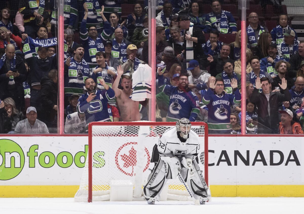 Vancouver fans celebrate behind Kings goalie Jonathan Quick after the Canucks scored their eighth goal of the night.