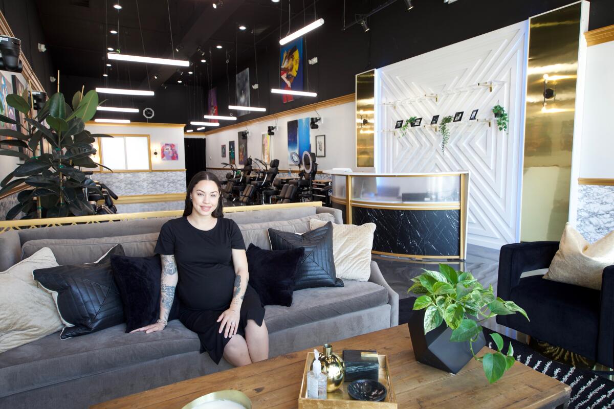 A woman sits on a sofa at a business.