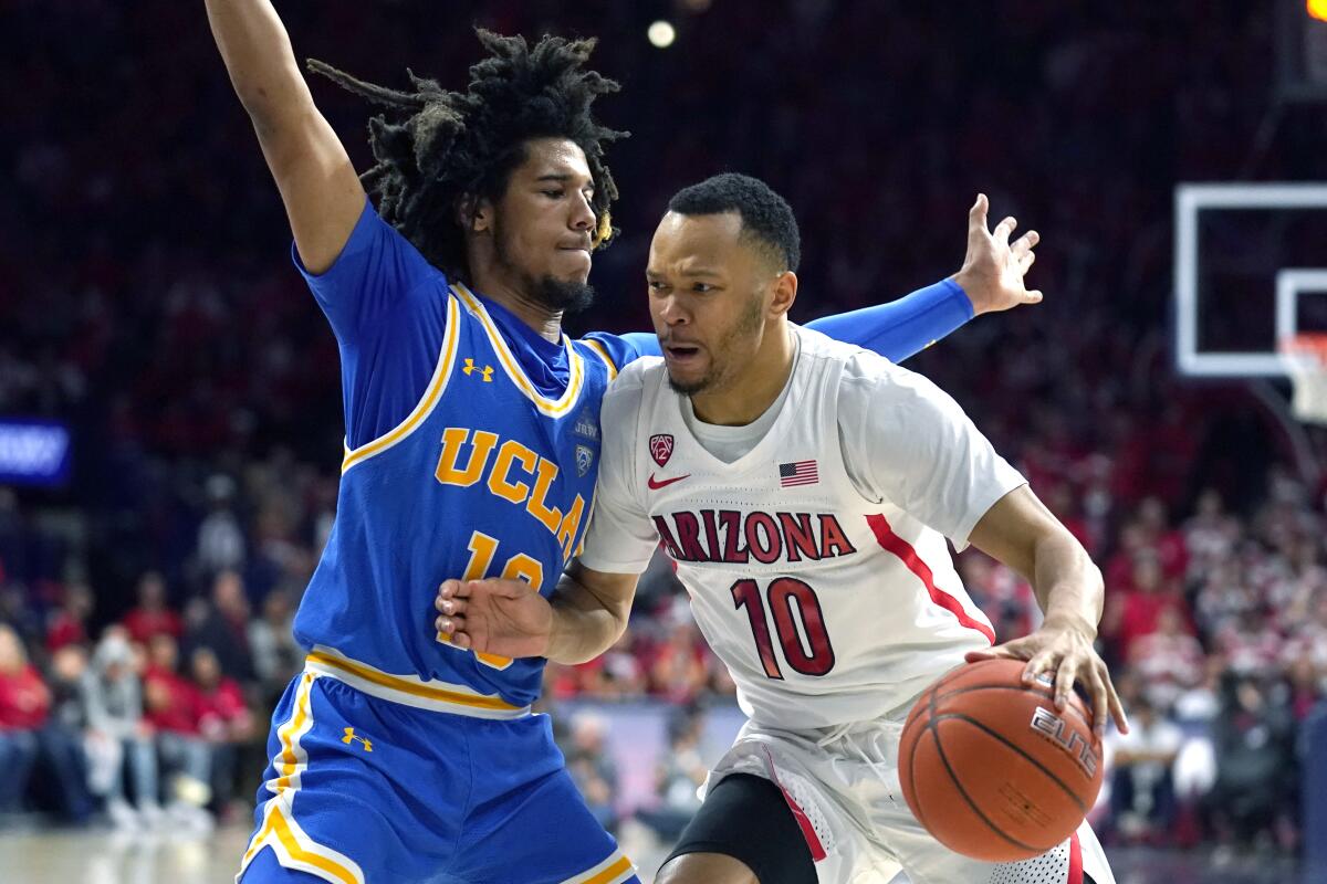Arizona guard Jemarl Baker Jr., right, drives on UCLA guard Tyger Campbell during the second half of the Bruins' upset win Saturday.