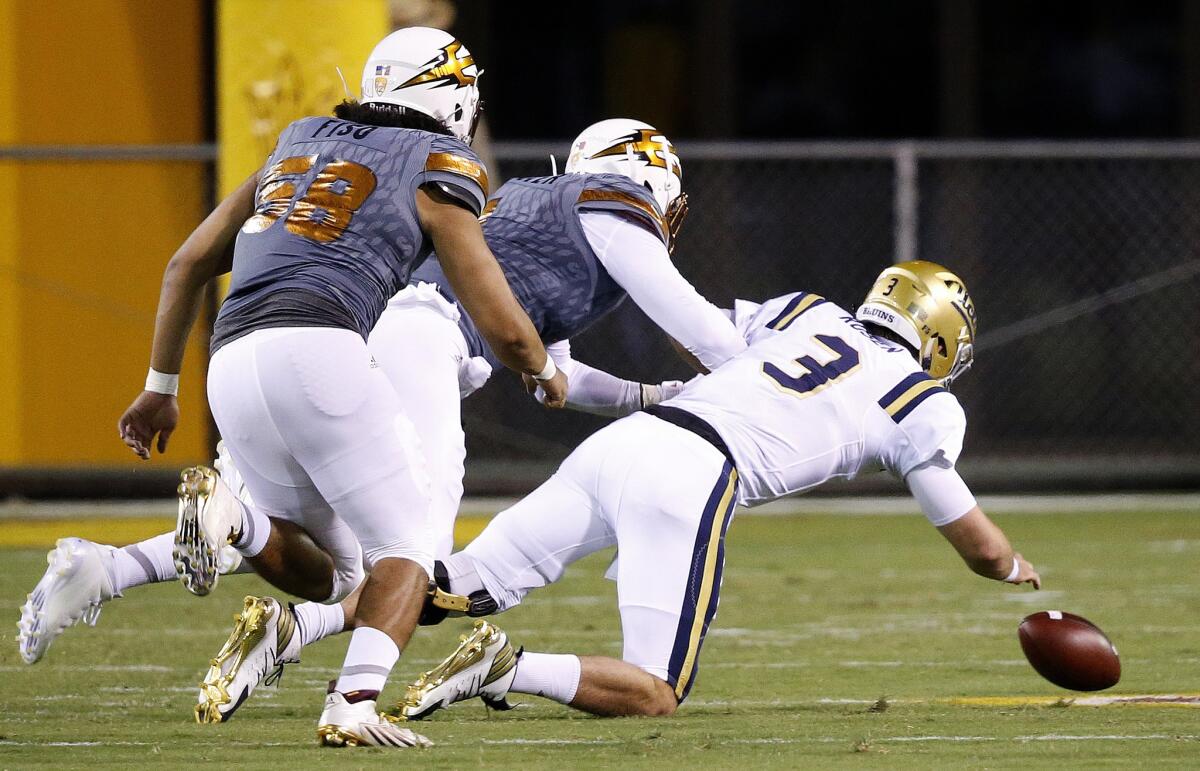 UCLA quarterback Josh Rosen (3) fumbles the ball as Arizona State defensive lineman JoJo Wicker, middle, and Salamo Fiso (58) move in to make a recovery during the first half.