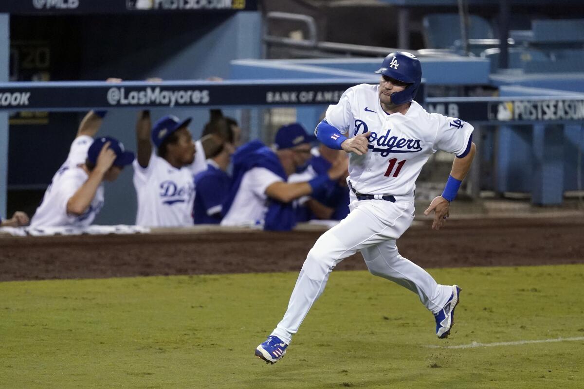 Dodgers' AJ Pollock rounds third base to score on a double by Mookie Betts.